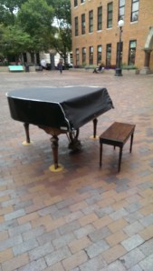 A lonely piano in a public plaza, under lock and key